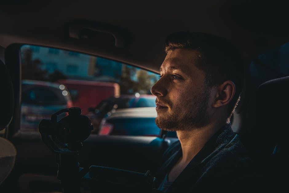 Moody portrait of a man sitting in a car, captured in Moldova during the day.